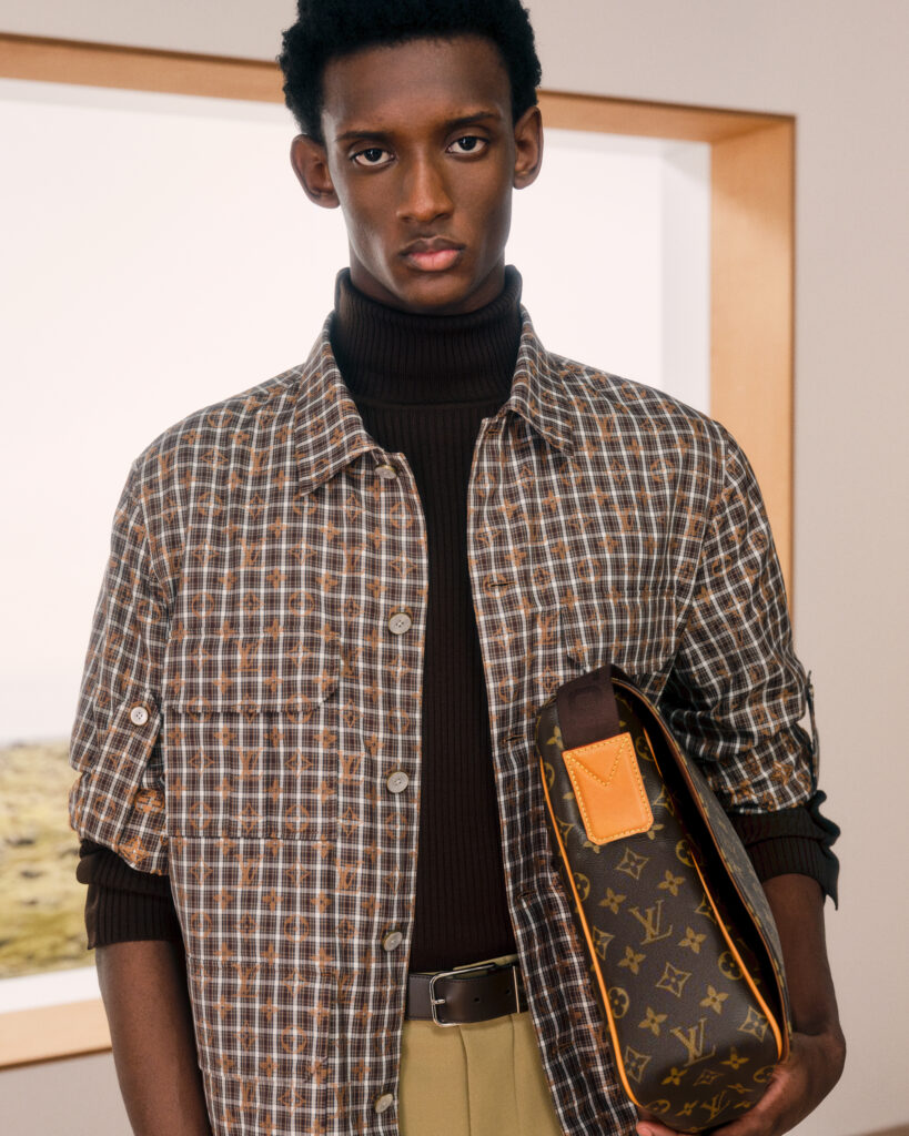 Détail du sac Speedy en cuir vernis bordeaux tenu à la main, Louis Vuitton Homme
