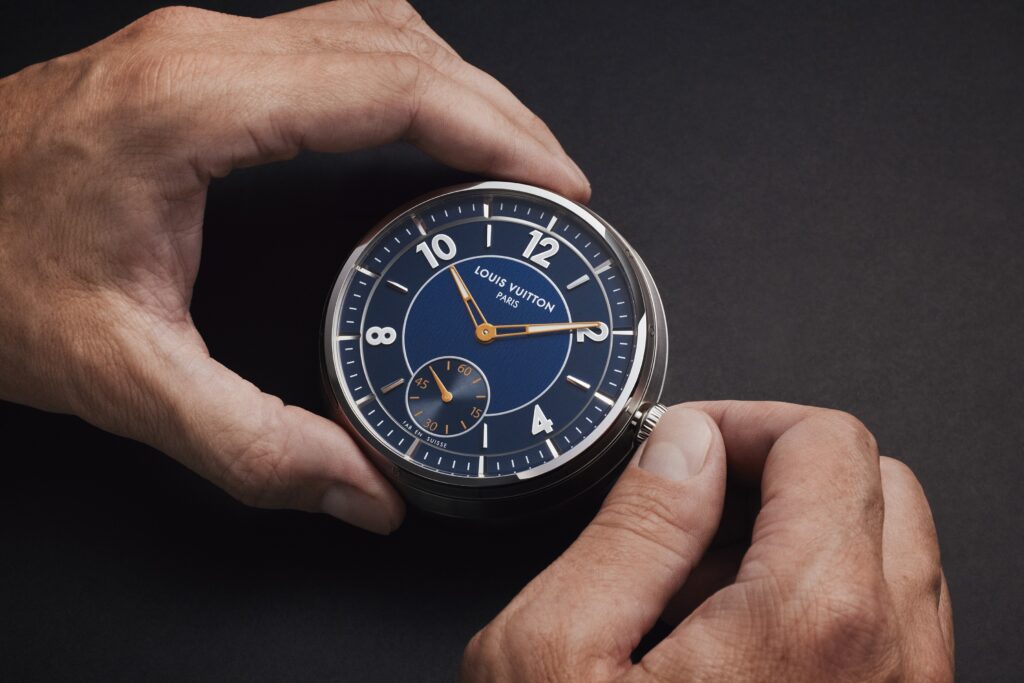 Horloge de bord au cadran bleu Louis Vuitton tenue en main