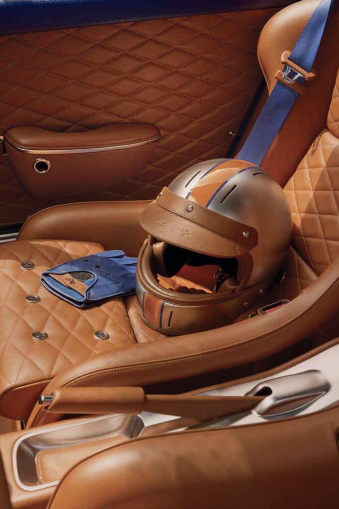 Casque et gants Louis Vuitton posés sur le siège en cuir de la Porsche 911 Singer