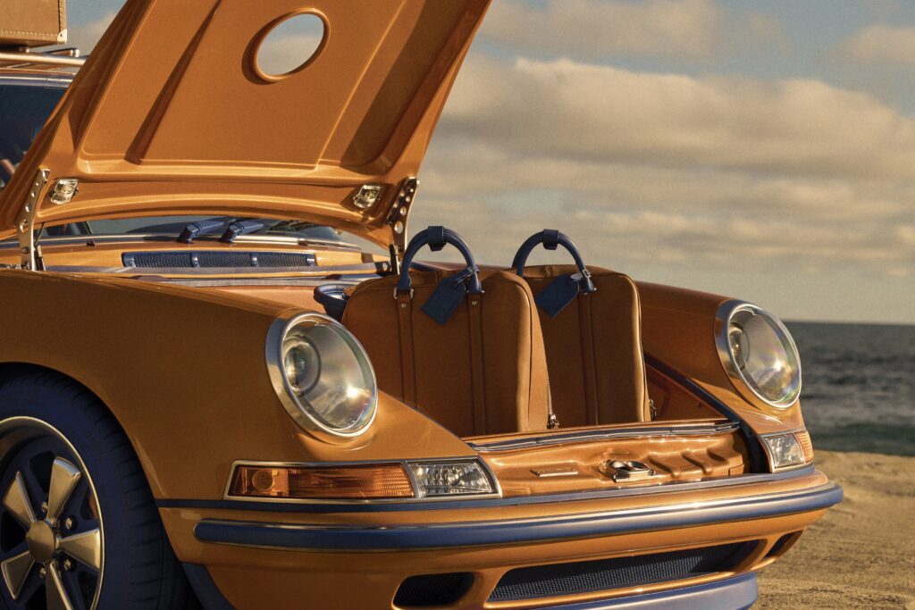 Malle avant de la Porsche 911 ouverte sur des valises en cuir Louis Vuitton