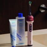 Brosse à dents Dyson CameraJet et système dentaire Dyson (dentifrice et bain de bouche) posés sur un lavabo