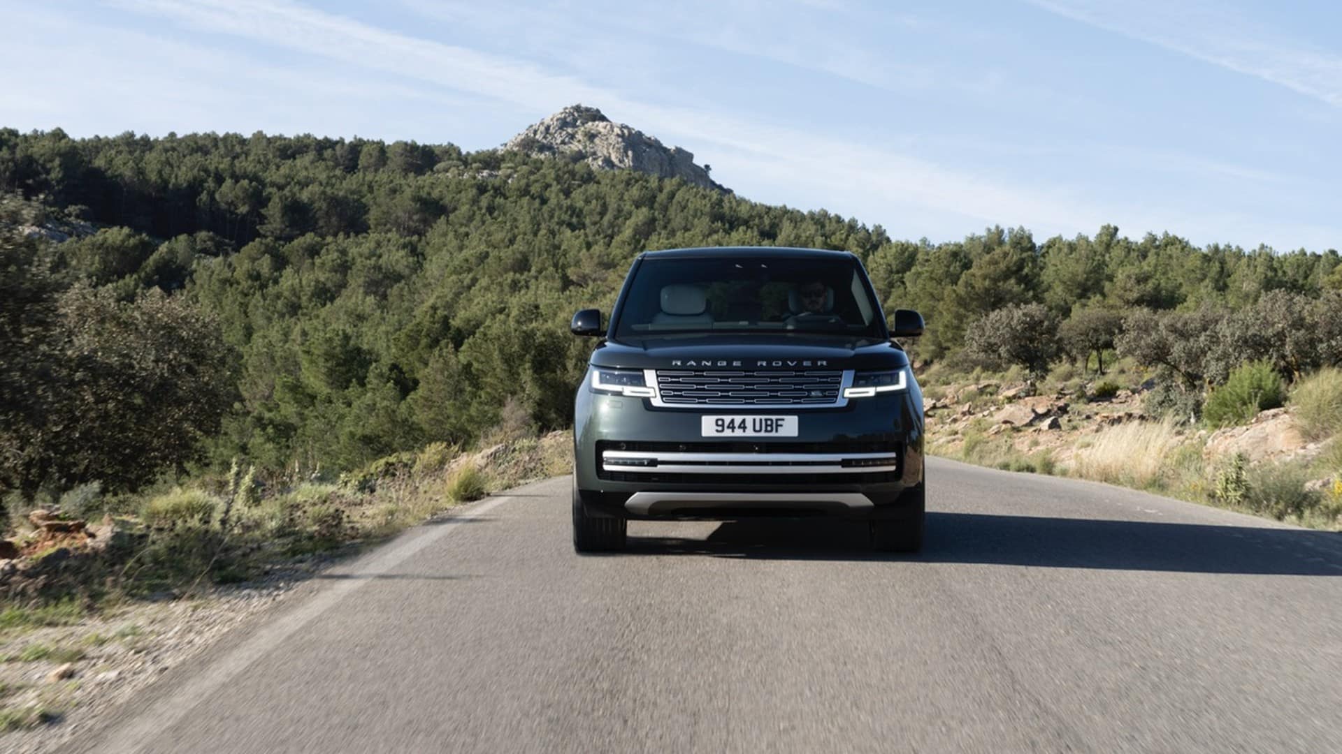 Range Rover Electric Belgravia Green sur une route de montagne