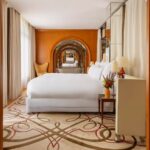 Suite du Royal Monceau – Raffles Paris avec lit et enfilade d'arches miroitées, l'hôtel où loge Céline Dion pour son retour à Paris