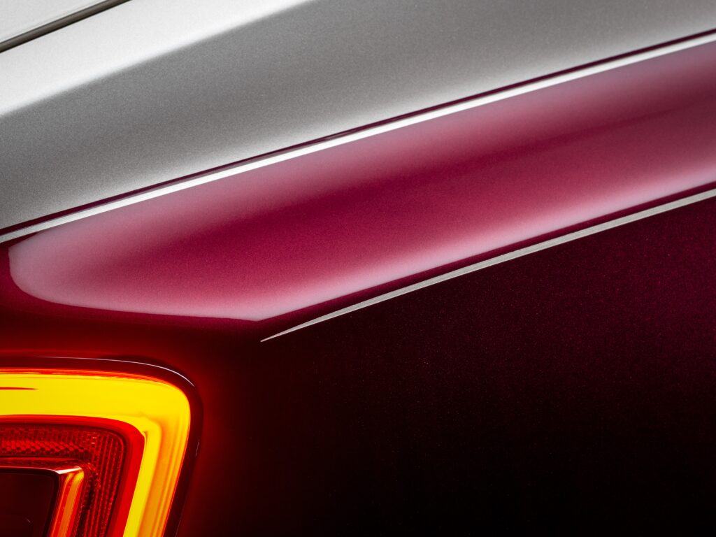 Détail de la carrosserie bicolore argent et bordeaux avec feu arrière allumé de la Rolls-Royce Phantom