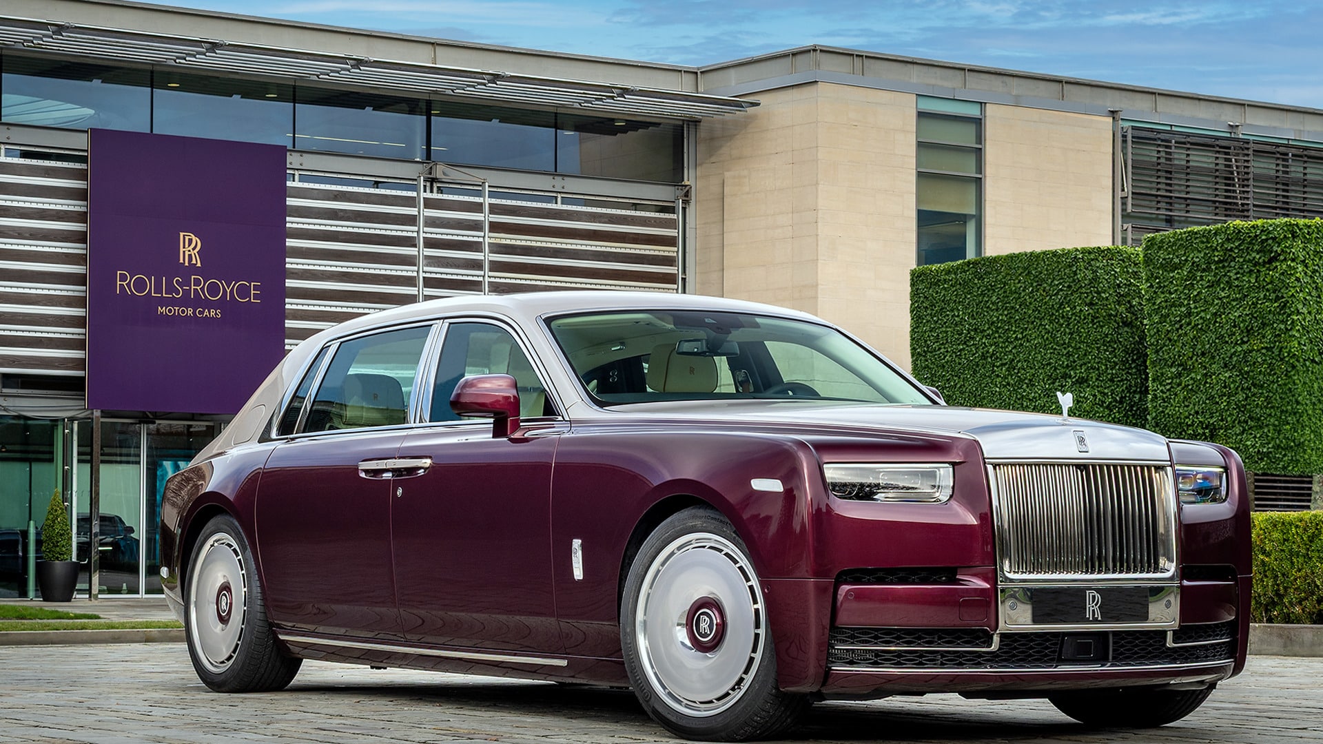 Rolls-Royce Phantom bordeaux vue de trois-quarts avant, garée devant le siège de Rolls-Royce Motor Cars