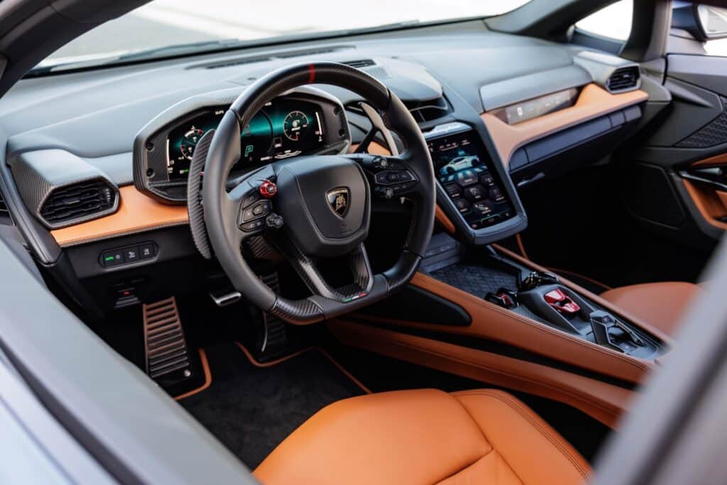 Intérieur de la Lamborghini Temerario avec volant sportif, sellerie orange et instrumentation numérique.