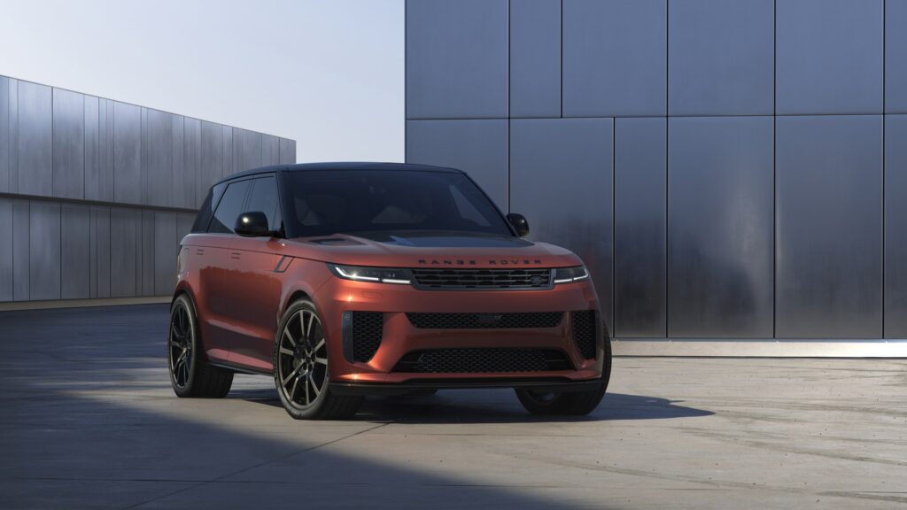 Les 10 SUV de luxe les plus sportifs en 2026 : Range Rover Sport SV Carbon cuivré à toit noir vu de trois-quarts avant devant une façade de métal