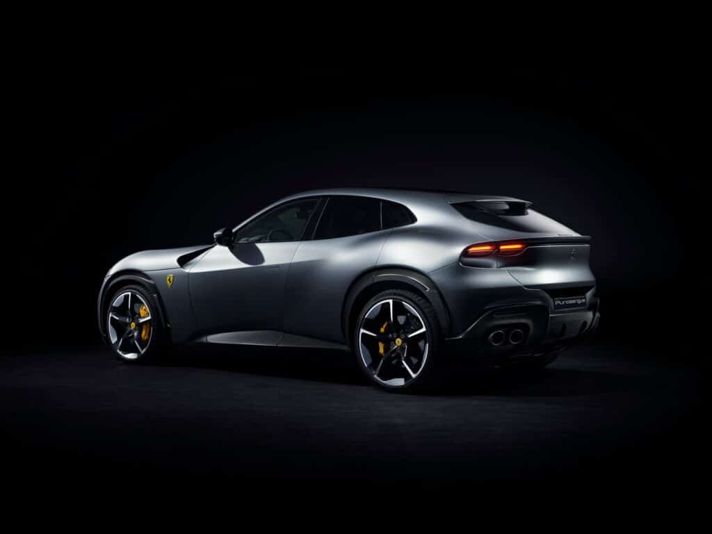 Ferrari Purosangue grise vue de trois-quarts arrière sur fond noir, feux et sorties d'échappement
