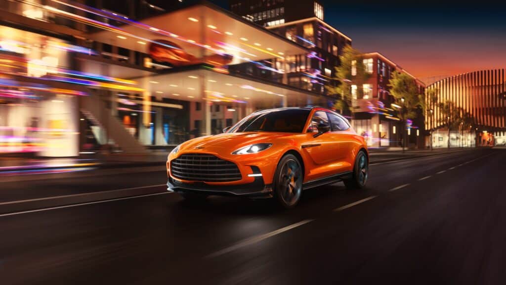 Les 10 Aston Martin les plus désirables en 2026 : Aston Martin DBX707 orange vue de trois-quarts avant, roulant de nuit en ville