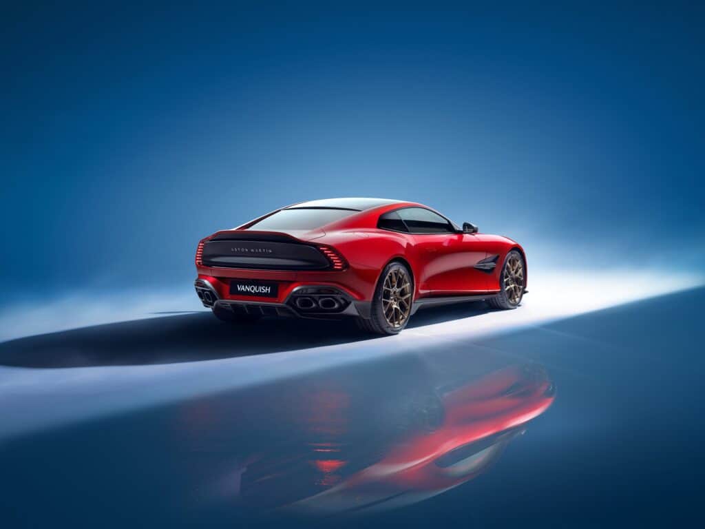 Aston Martin Vanquish coupé rouge vue de trois-quarts arrière sur fond bleu