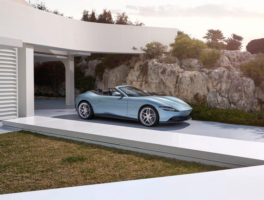 Les 10 Ferrari modernes les plus désirables en 2026 : Ferrari Roma Spider bleu clair capote ouverte, vue de trois-quarts avant devant une villa