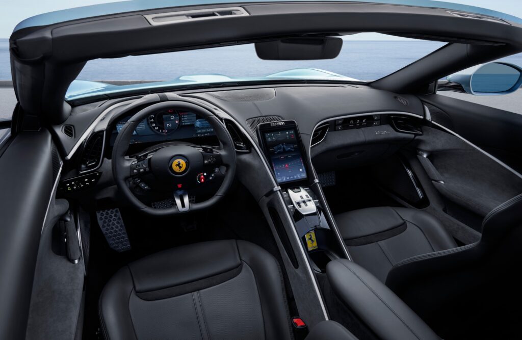Habitacle de la Ferrari Roma Spider capote ouverte, volant, écran central et sièges noirs