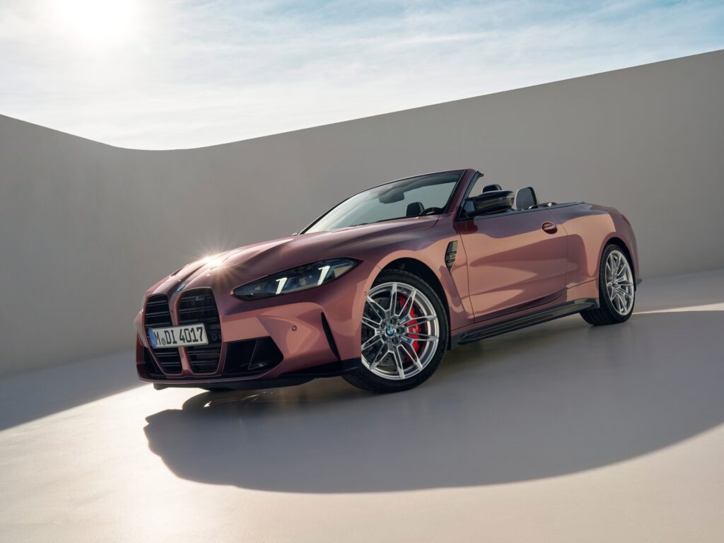 Les 10 cabriolets de luxe les plus désirables en 2026 : BMW M4 Competition Cabriolet M xDrive vieux rose décapotée dans un décor de studio, vue de trois-quarts avant