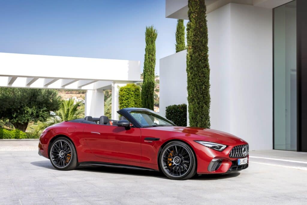 Les 10 cabriolets de luxe les plus désirables en 2026 :Mercedes-AMG SL 63 4MATIC+ rouge décapotée devant une villa blanche, vue de trois-quarts avant