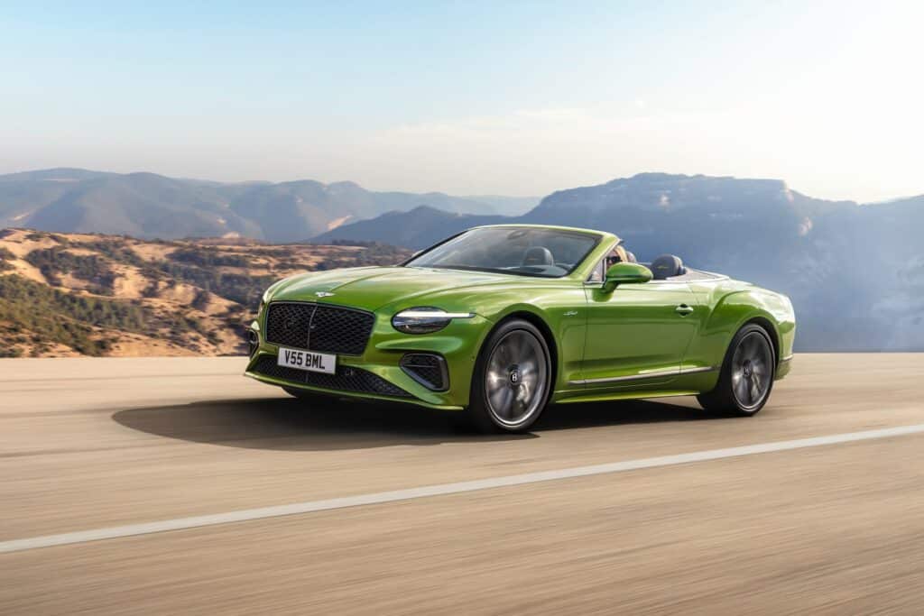 Les 10 cabriolets de luxe les plus désirables en 2026 :Bentley Continental GTC Speed verte décapotée sur une route de montagne, vue de trois-quarts avant