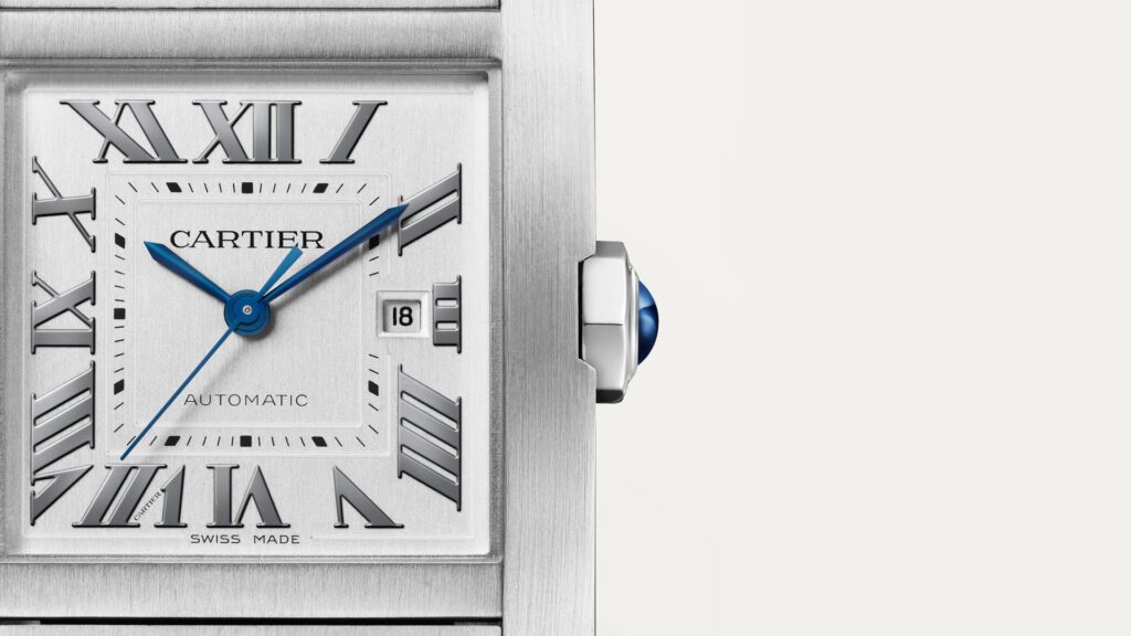 Gros plan du cadran argenté de la Cartier Tank Française automatique en acier, chiffres romains et aiguilles bleuies