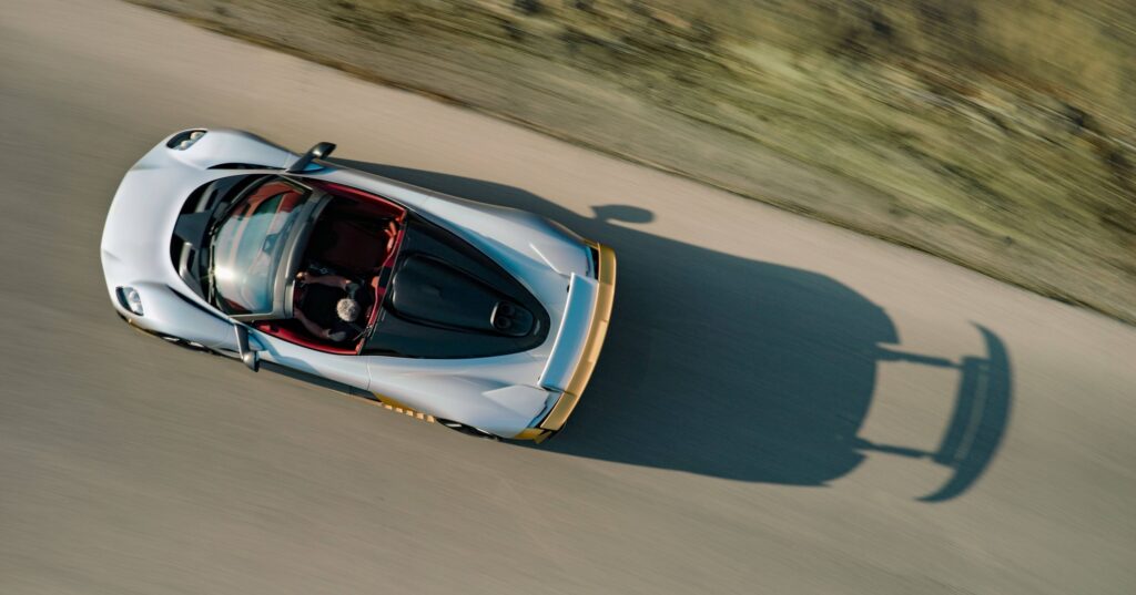 Vue aérienne de l’Aston Martin Valhalla Spider roulant toit retiré, habitacle rouge visible